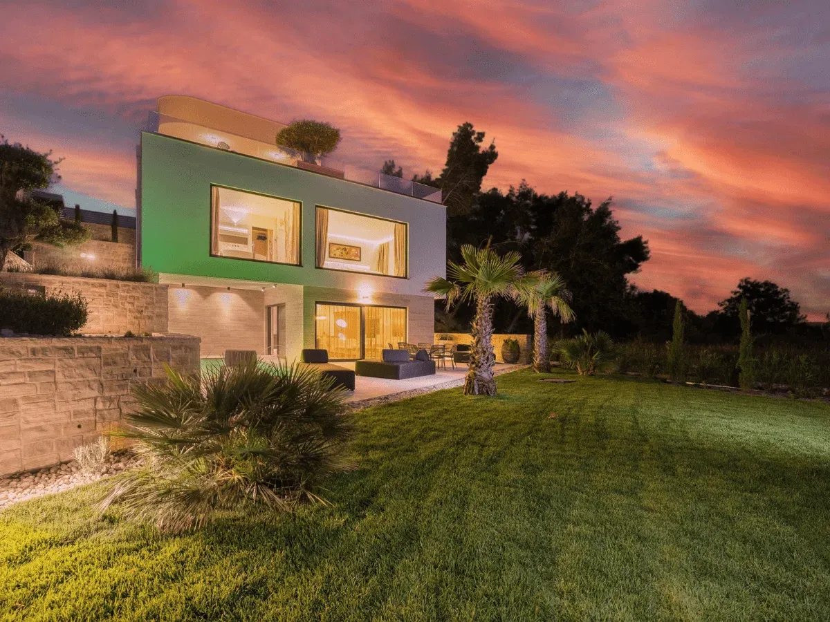 Vrt obalne vile s bujnim nasadima i elementima prirodnog kamena